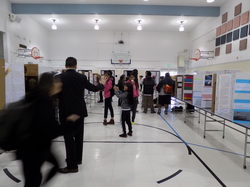 Students walking around the gym looking at presentations